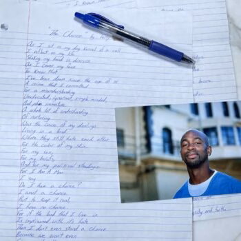 A handwritten poem titled "The Chance" by Terry on lined paper, accompanied by a blue pen and a portrait of a smiling Black man in a blue shirt.