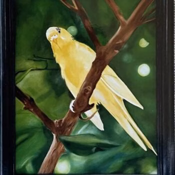 A yellow bird perched on a tree branch in a green, leafy background.