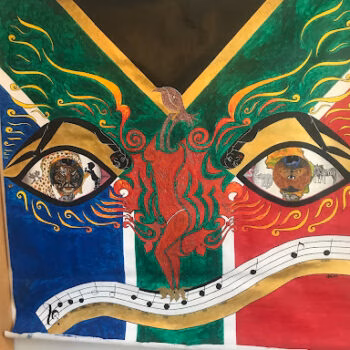 A vibrant tapestry featuring two large eyes with intricate portraits inside, a central red figure, and a musical staff across the bottom, set against a green, yellow, and blue background.