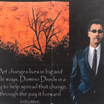 A man in a blue suit and sunglasses stands next to a stylized orange and black graphic of a tree. Text below reads: 'Art changes lives in big and little ways, Domino Deeds is a way to help spread that change, through the pay it forward initiative.'