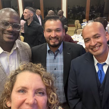 A group of five people, including Jerry 2, smiling for a photo at a formal event.