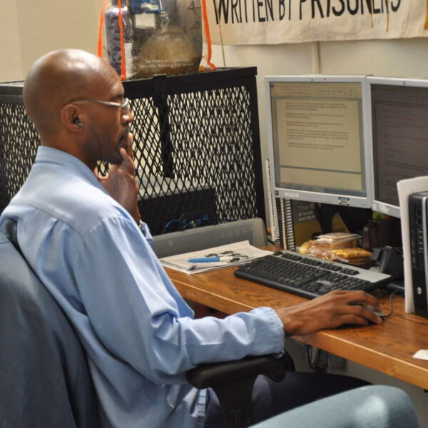 Jonathan Chiu, a man in a blue shirt and glasses, works at a desk with multiple monitors during the HealthFair on August 24, 2018.