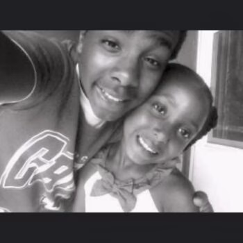 A black and white selfie of Kyaleah and a young boy smiling together.