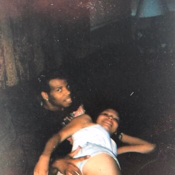 A man named Michael holds a young child in a dark, grainy photograph.