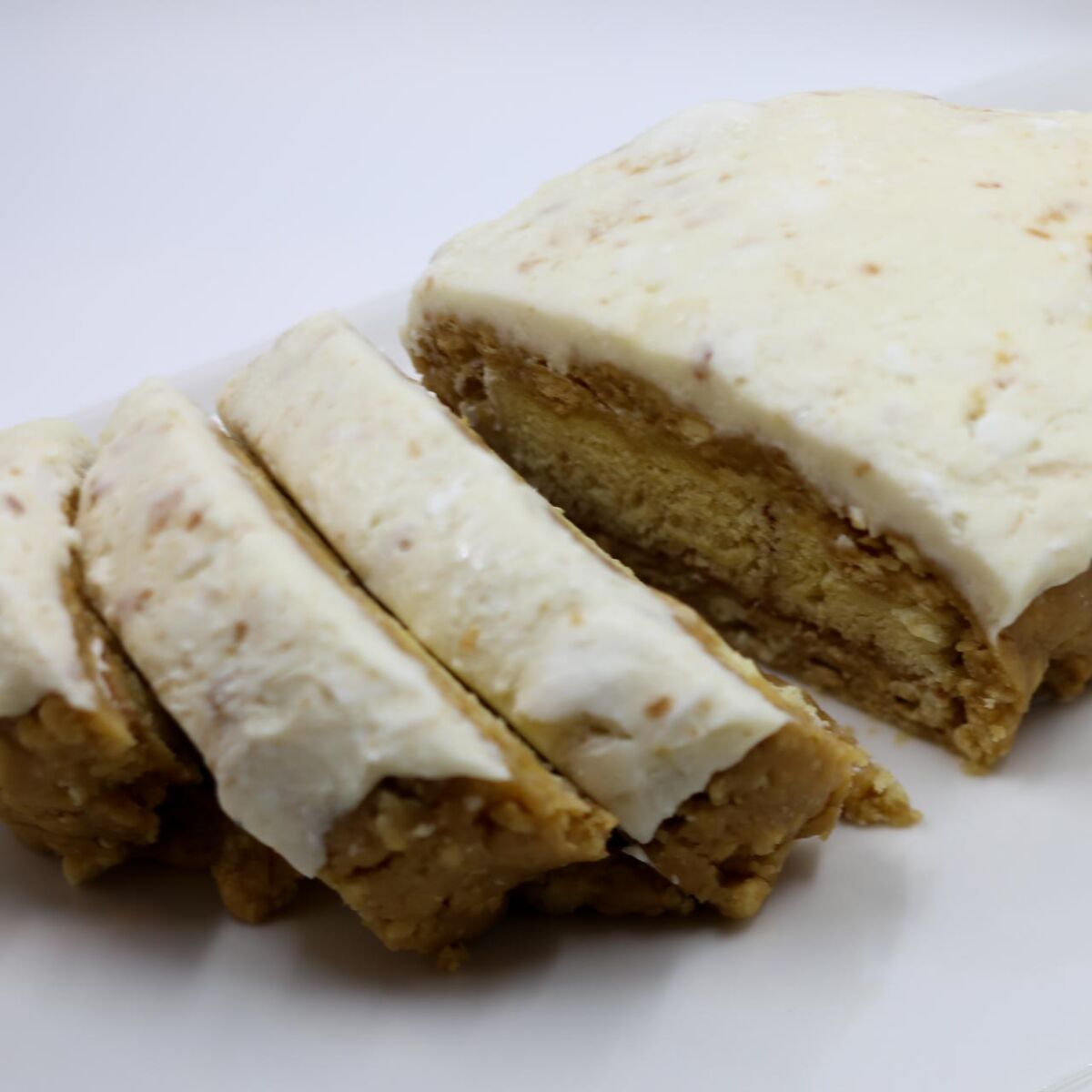 Photo of a sliced tan cake with white frosting