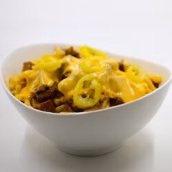 Photo of Mac & Mak in a white bowl and covered with cheese and peppers