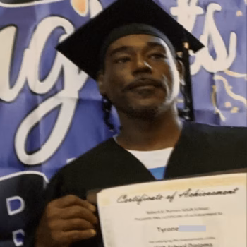 Graduation Certificate A man in a graduation cap and gown holds a certificate of achievement for a high school diploma.