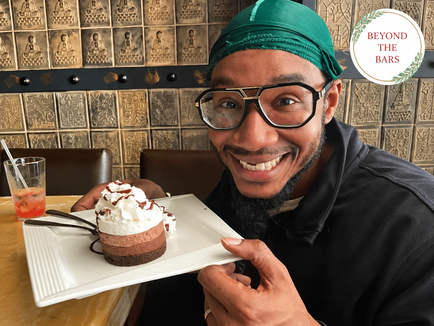 Andrew smiling while holding a plate with cake