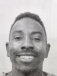 Close-up portrait of Ray, a smiling man with short hair and a light beard, looking directly at the camera.