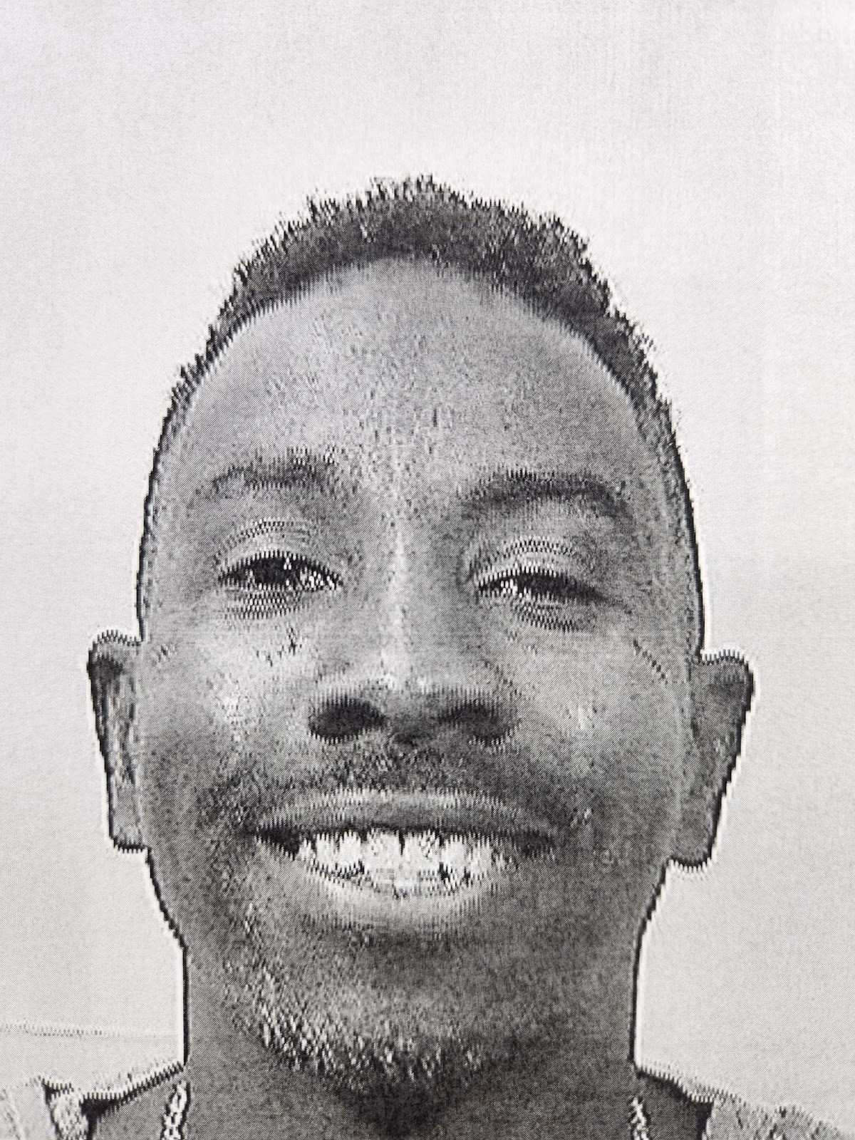 Close-up portrait of Ray, a smiling man with short hair and a light beard, looking directly at the camera.