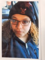 Katherine wearing a black beanie with a red Chicago Bulls logo, glasses, and a blue jacket.