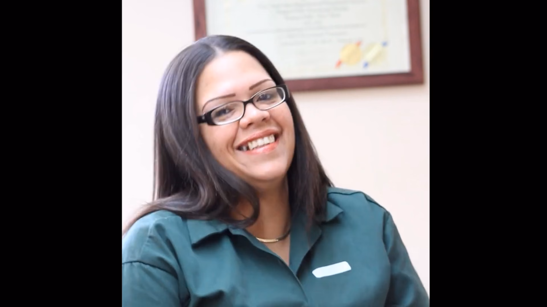 Kristal, 31, smiling while wearing glasses and a green shirt.