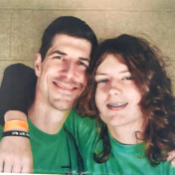 Lucas and a woman in green shirts smiling together.