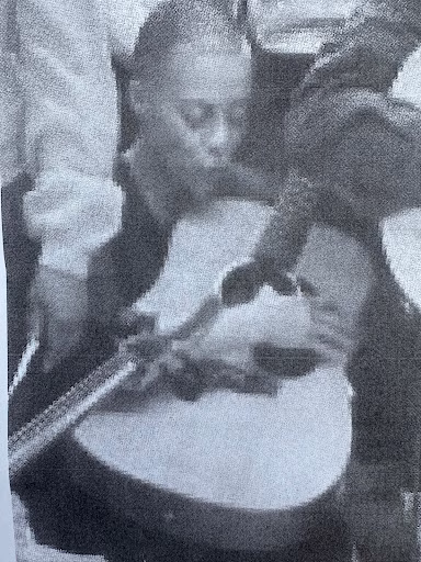 A person plays a cello in a black and white photograph.