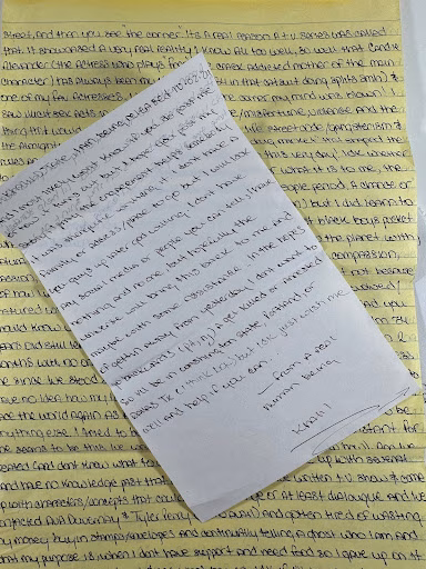 A handwritten note on yellow lined paper with the name Khalil at the bottom, resting on a background of printed text.