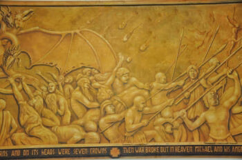 A golden relief mural depicting a chaotic battle scene with numerous figures wielding spears against a dragon, with a banner at the bottom reading 'AND ITS HEADS WERE SEVEN CROWNS THEN WAR BROKE OUT IN HEAVEN MICHAEL AND HIS ANGELS'.