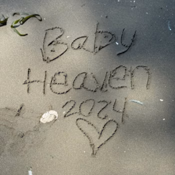 The words 'Baby Heaven 2024' are written in the sand, accompanied by a heart symbol.