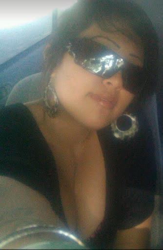 A woman named Irie wearing large sunglasses and hoop earrings, captured in a selfie.