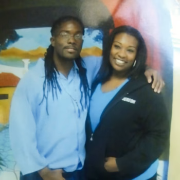 Marcus and Ja'far, 46, posing together in front of a colorful mural.