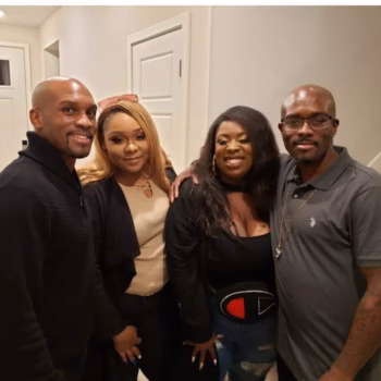Four people, Marcus and three others, posing together indoors.