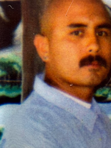 Portrait of Richard, a man with a mustache and a light blue shirt.