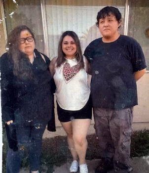 Three people standing together outside a building.