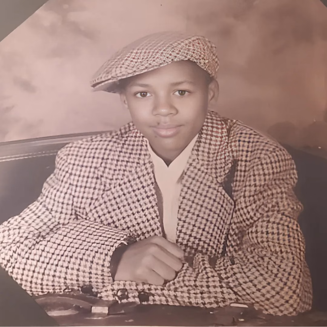 A vintage sepia-toned portrait of Craig, 36, wearing a houndstooth flat cap and matching jacket.