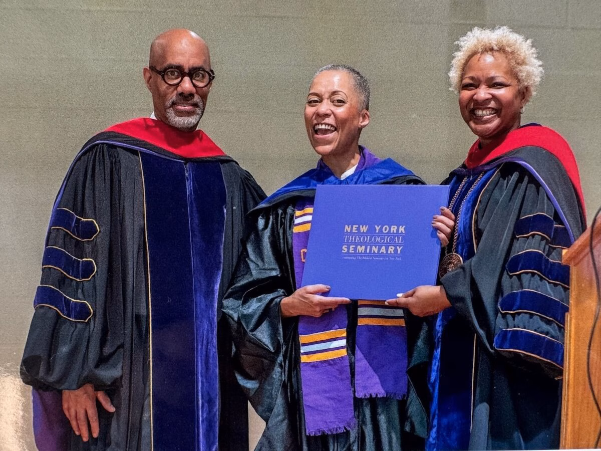 Three people in academic regalia holding a blue certificate from New York Theological Seminary.