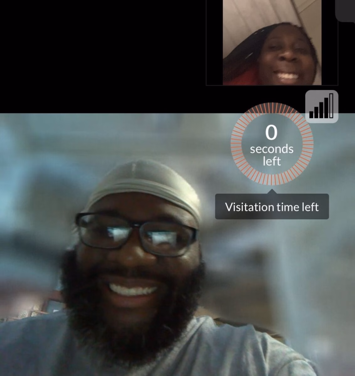 A man with a beard and glasses smiles during a video call, with a '0 seconds left' timer for visitation time displayed on the screen.
