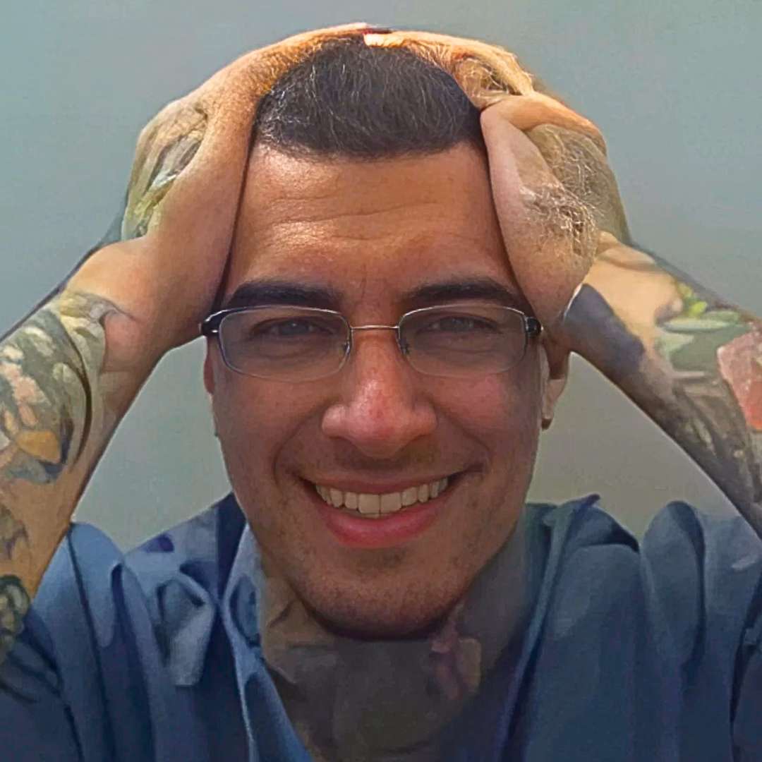 Jason, 27, smiling with hands on his head, wearing glasses and a blue shirt.
