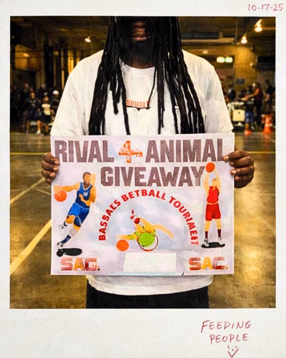 A person with long dreadlocks holds a sign for the Bassa's Betball Tournament, featuring illustrations of basketball players and the text 'Rival 4 Animal Giveaway' and 'SAC.'