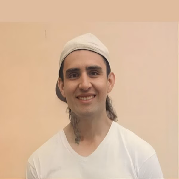 Erick MACIEL smiling, wearing a white cap and t-shirt against a plain background.