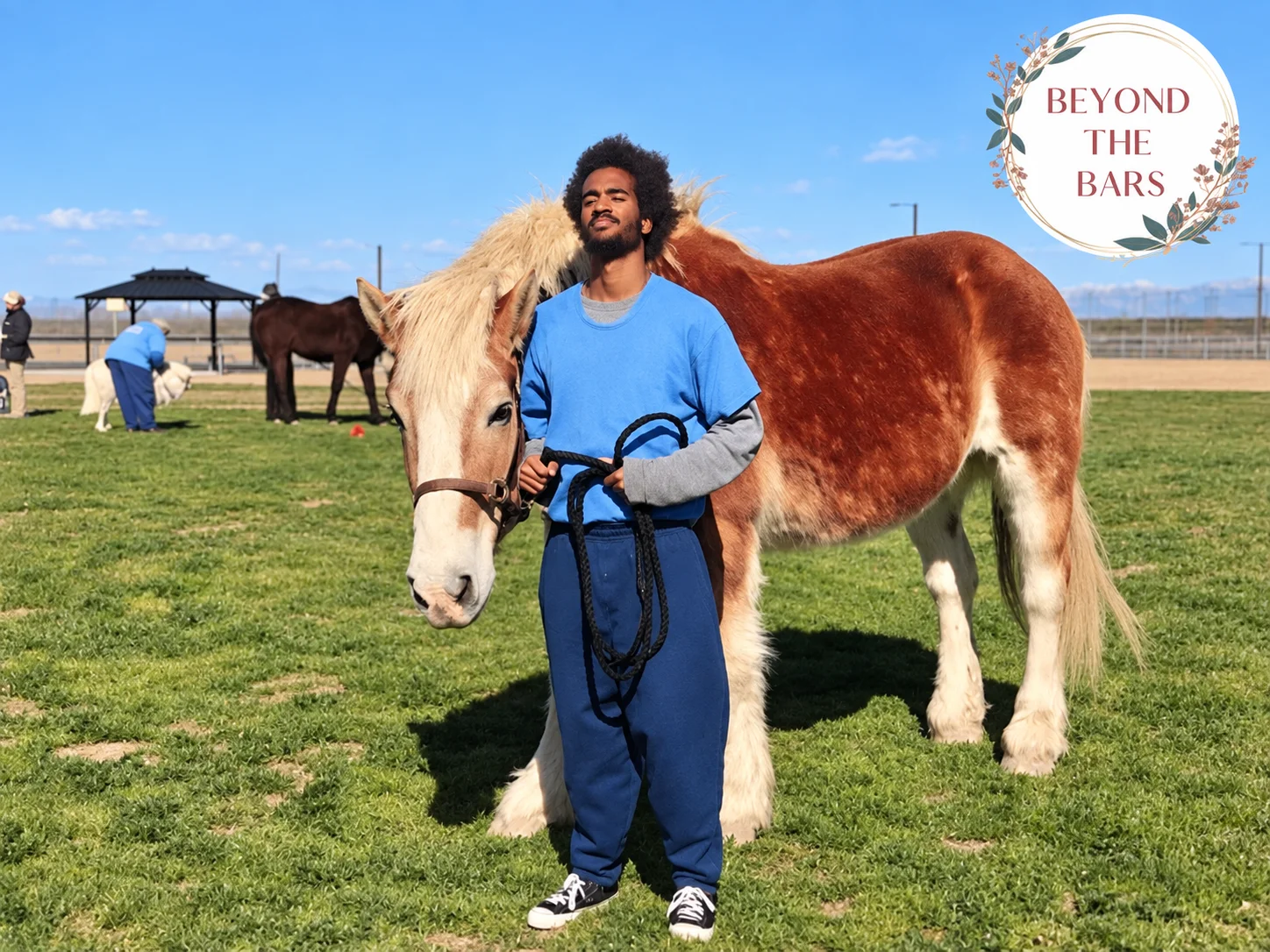 Marcus Smith, 23, stands with a large brown and white horse on a green field.