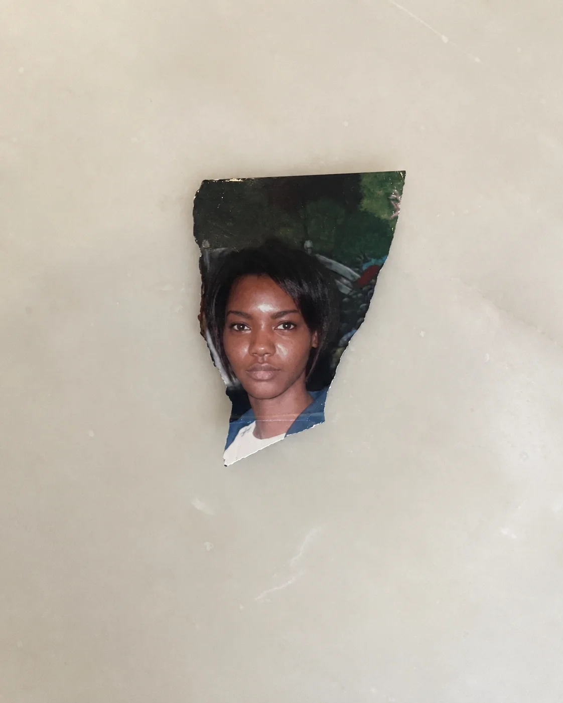 Torn portrait photo of a woman centered on a light neutral background with space for a story title