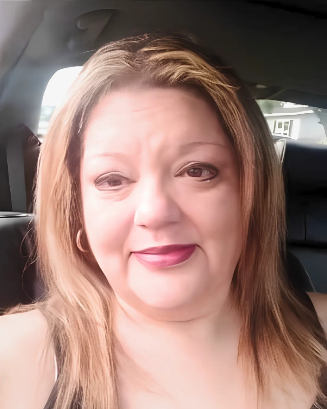 Close-up portrait of Estefana smiling inside a car, featured alongside her story about family, resilience, and finding purpose during incarceration.